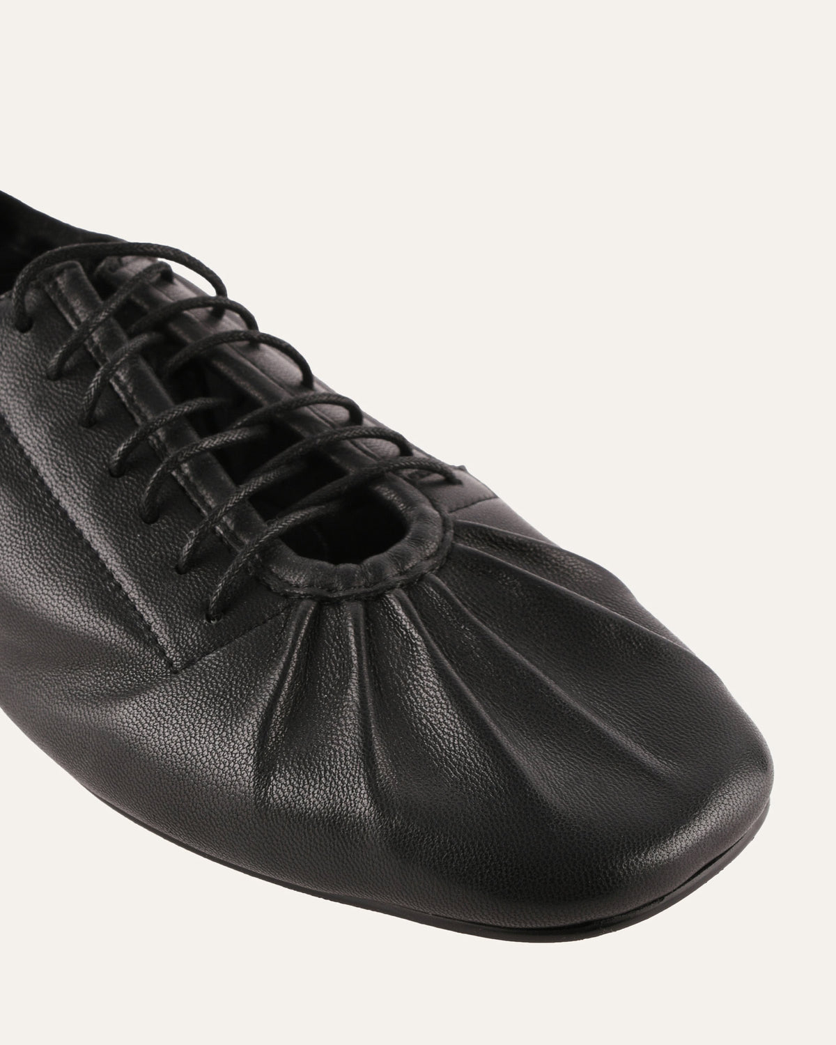 Black leather shoe with a soft sole on a white background
