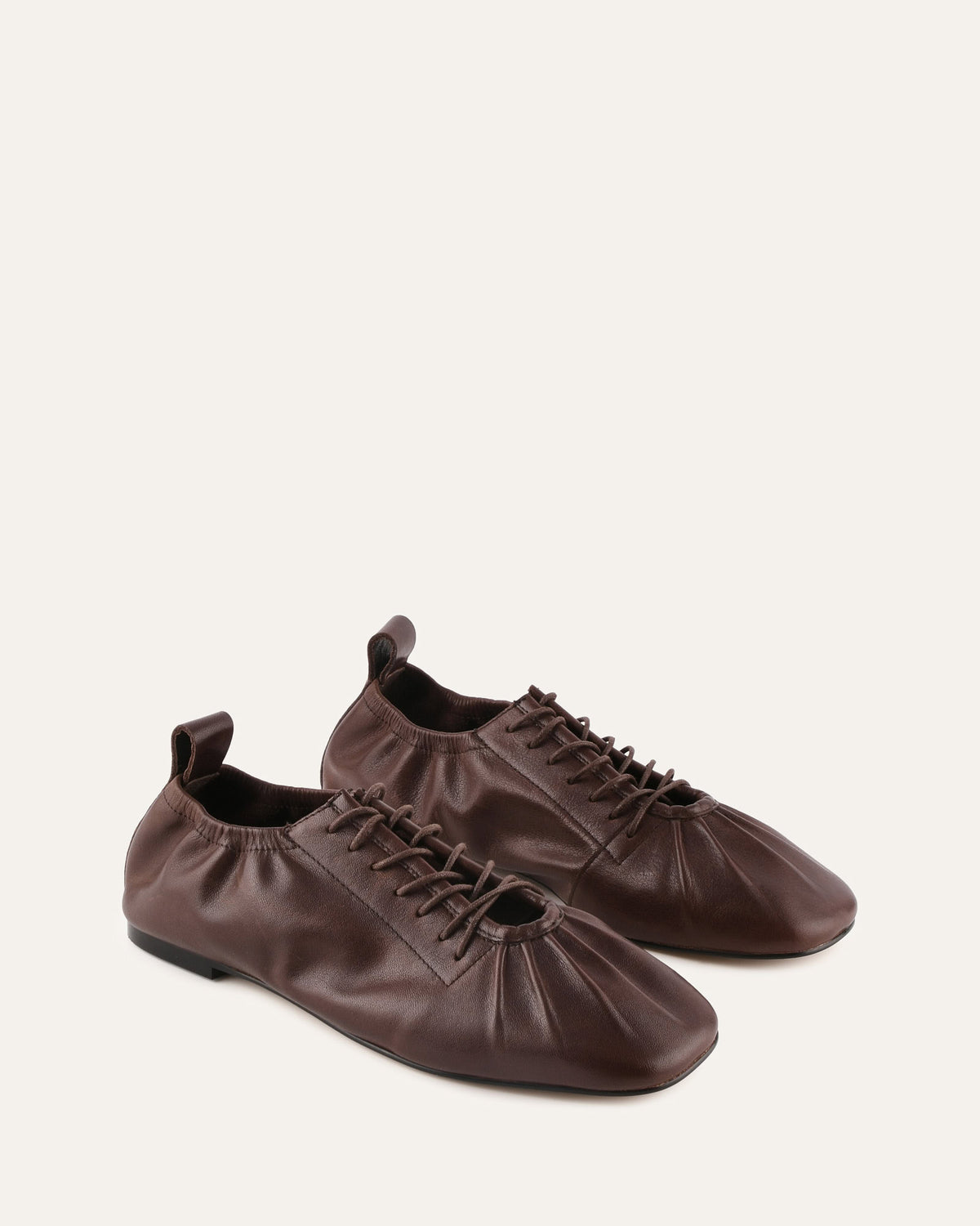 Pair of brown leather shoes on a light beige background