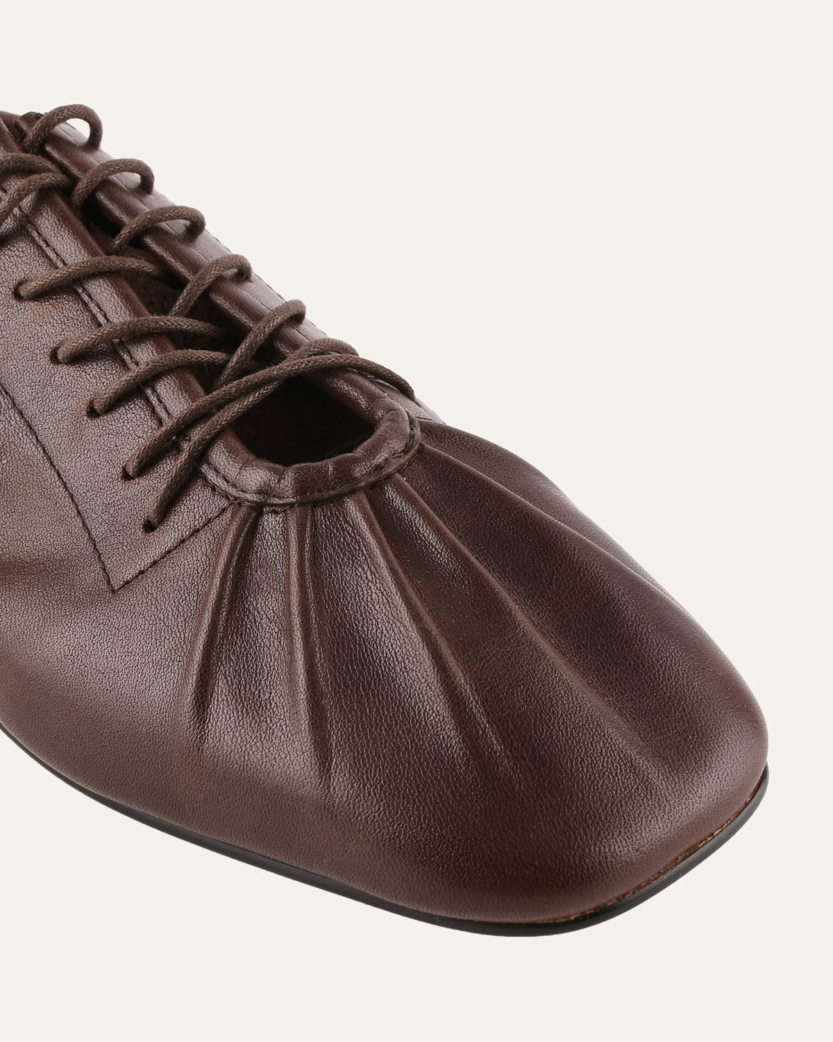 Brown leather shoe with laces on a white background
