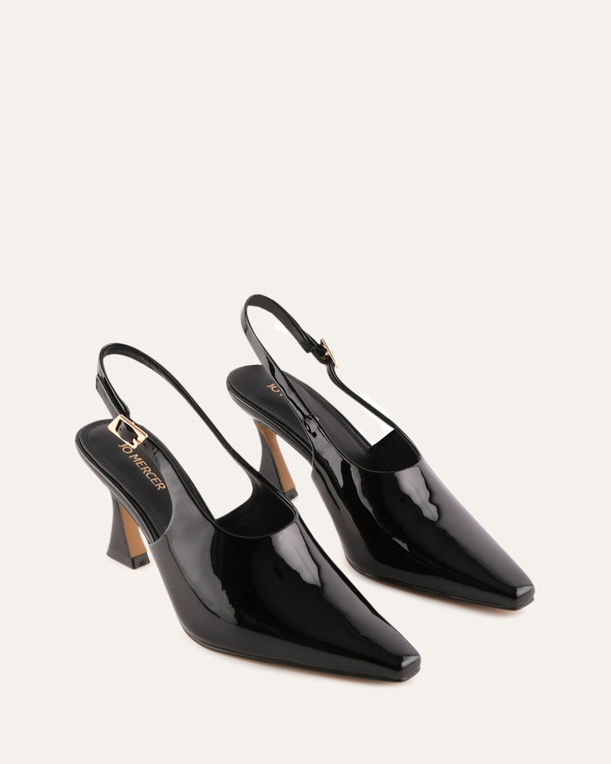 Pair of black patent leather slingback heels on a light gray background