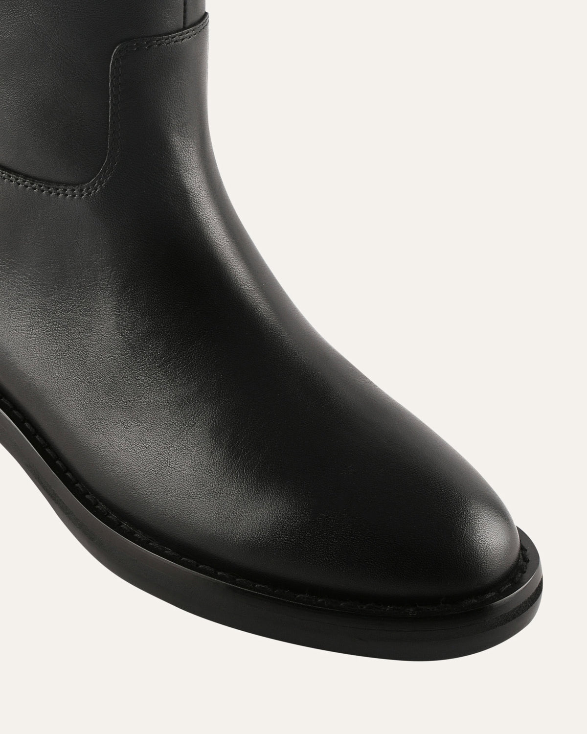Black leather boot on a light gray background
