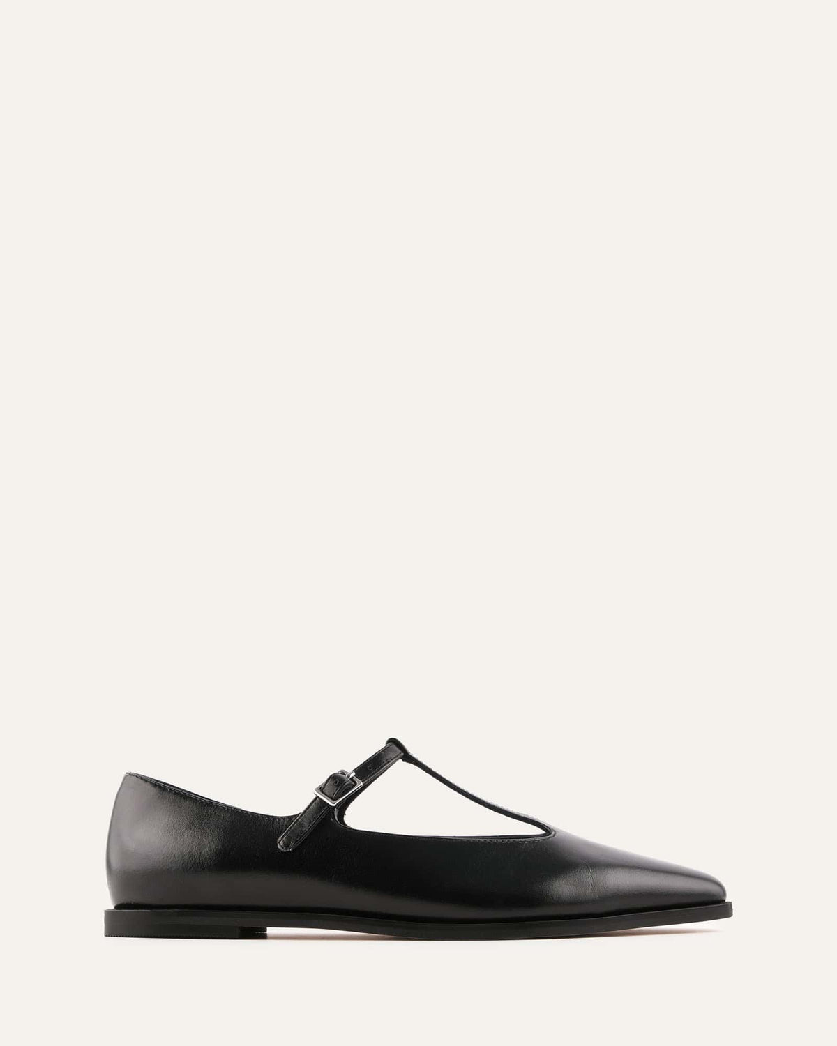 Black flat shoe with a strap on a white background