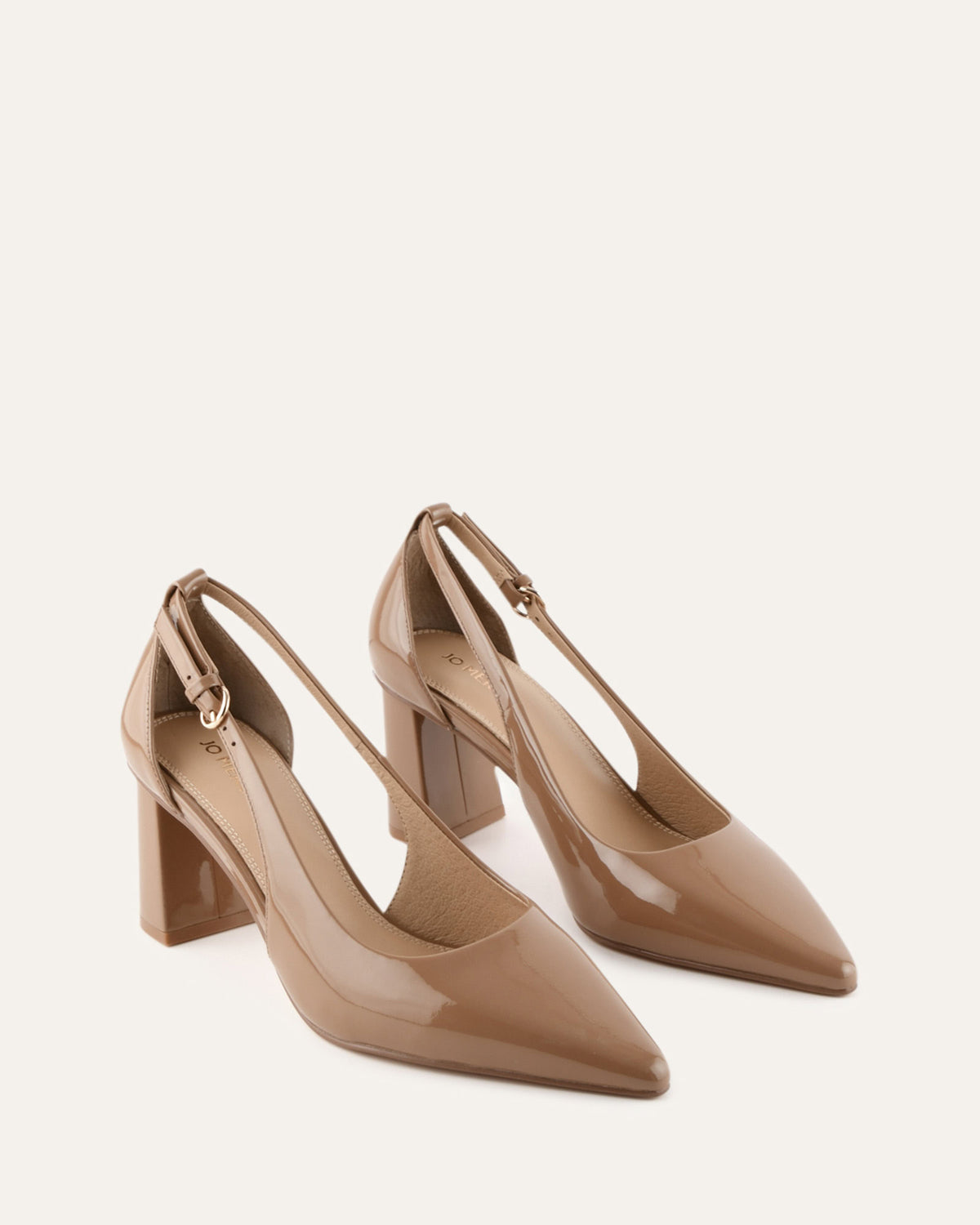 Pair of beige high-heeled shoes on a light background