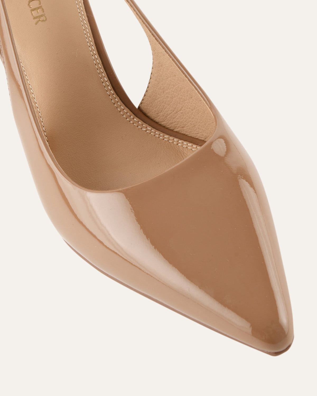 Beige high-heeled shoe on a light gray background