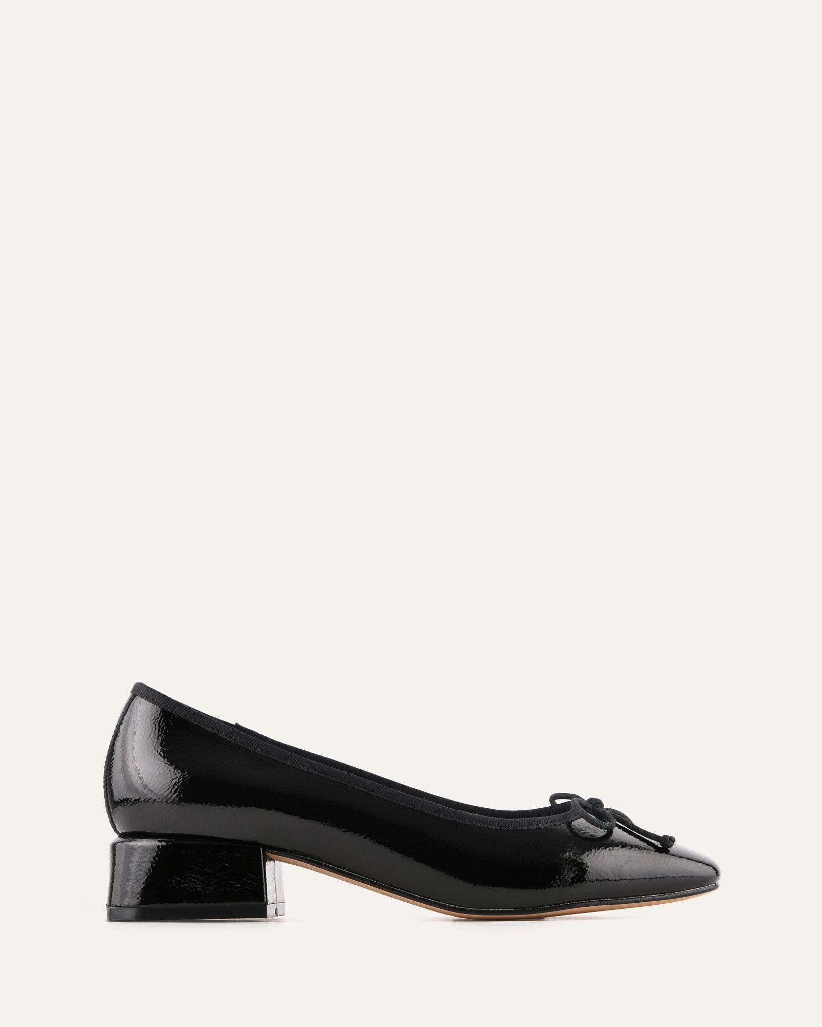 Black patent leather shoe with a bow on a white background