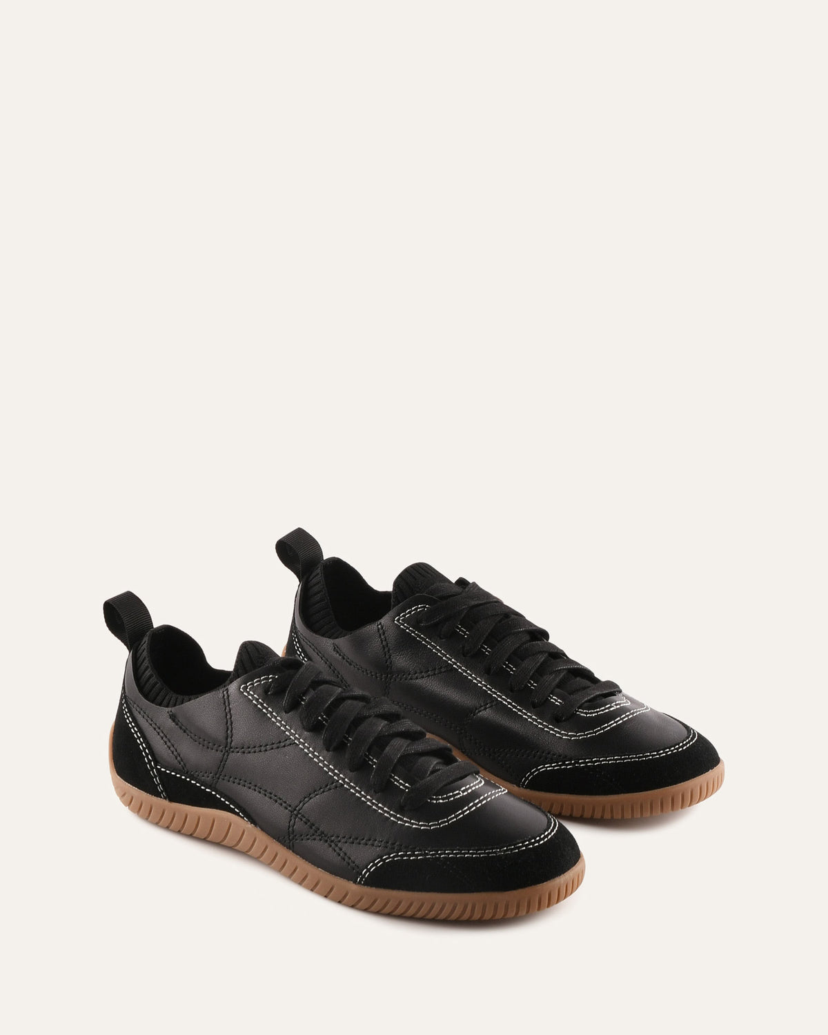 Pair of black sneakers with brown soles on a white background