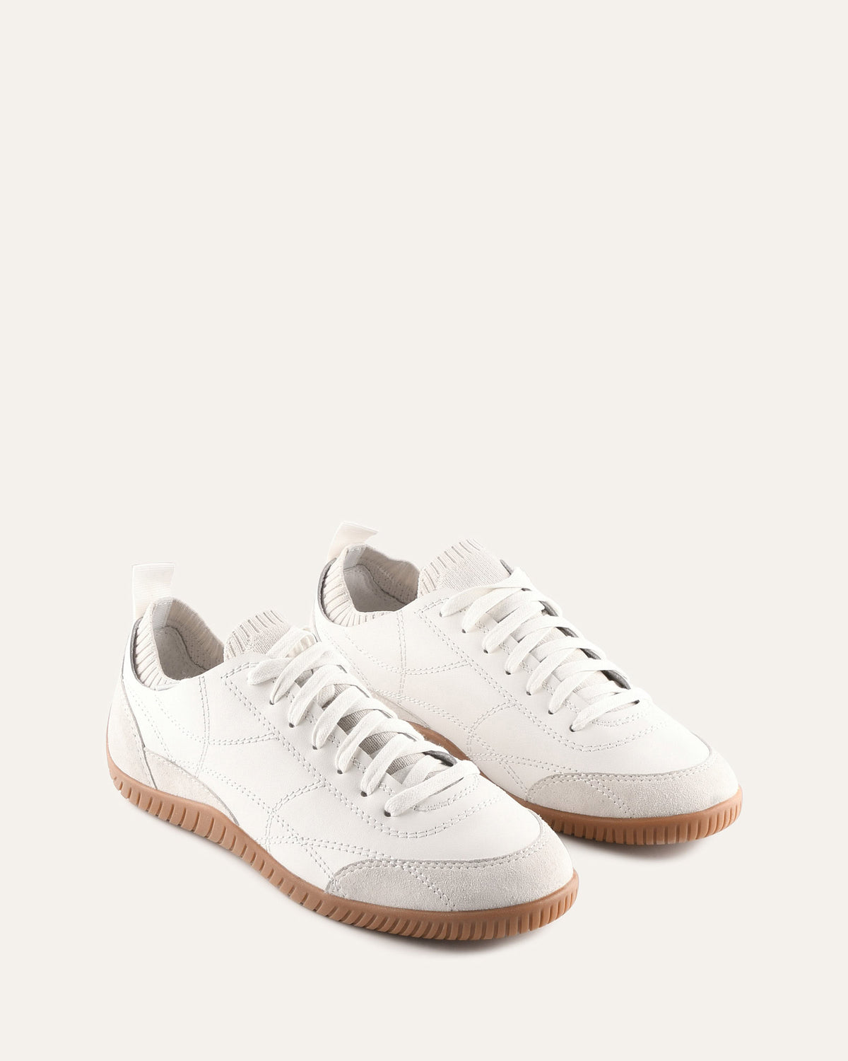 White sneakers with brown soles on a light gray background