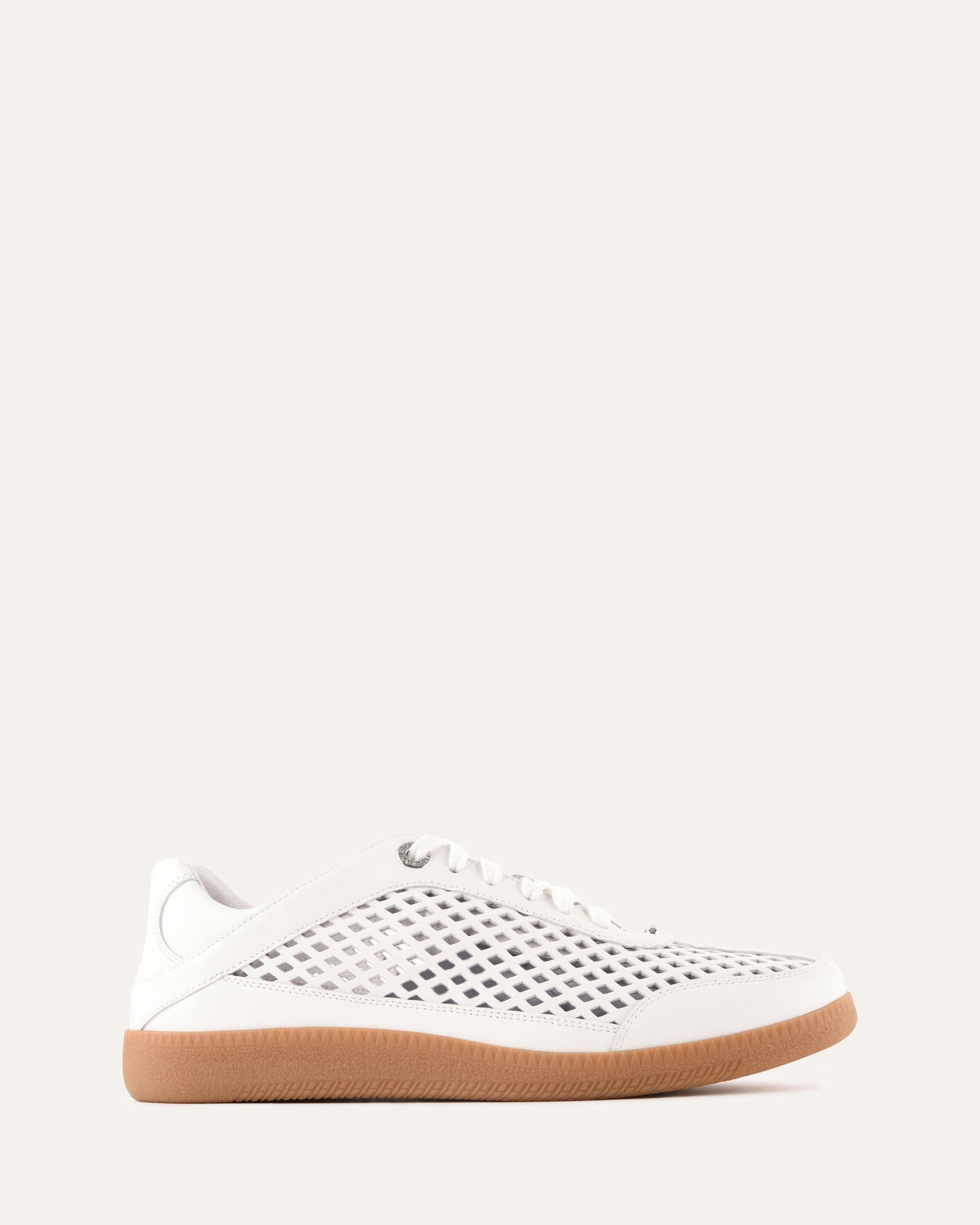 White sneaker with a brown sole on a light gray background