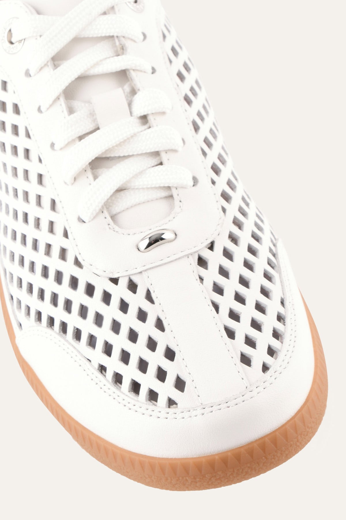 White sneaker with a brown sole on a white background