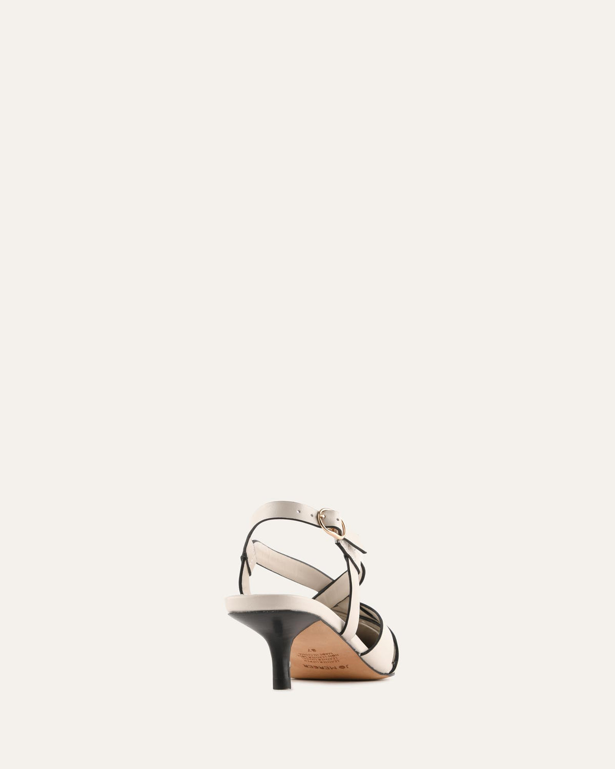 A single women's strappy sandal shown from the back on a plain off-white background. The sandal features a low kitten heel, a beige leather upper with thin black straps, and a small gold-tone buckle detail on the ankle strap.
