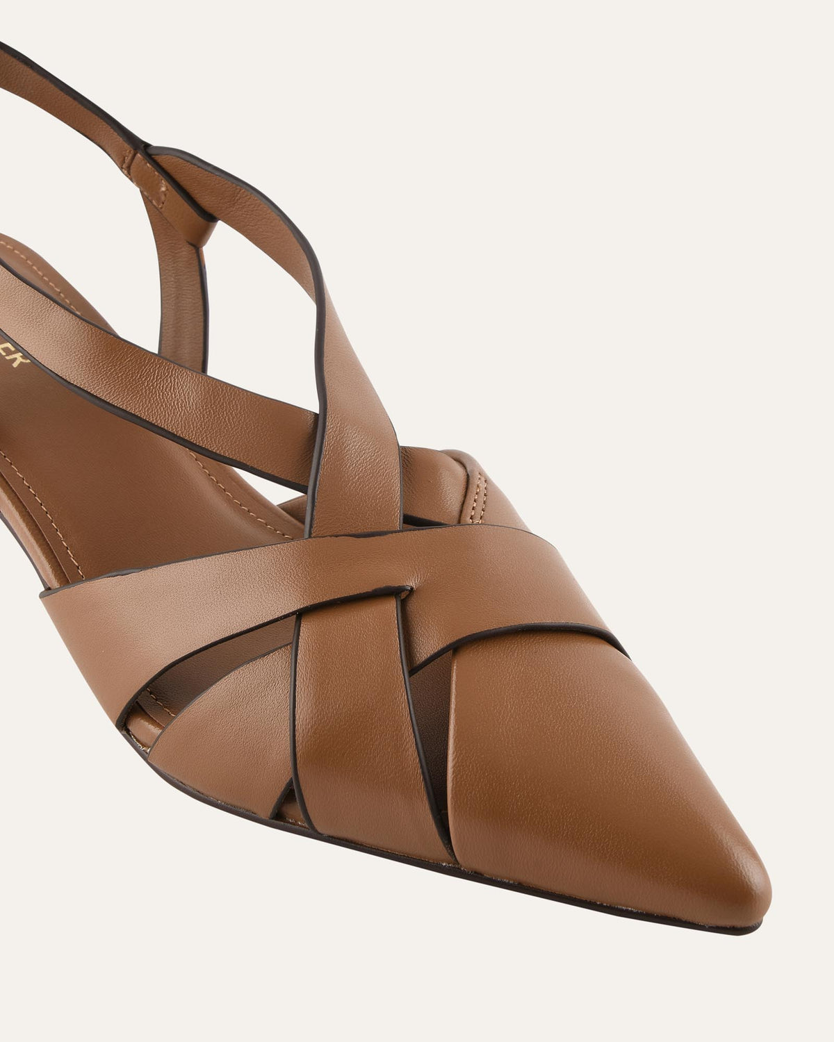 A close-up of a brown leather pointed-toe sandal with crisscrossing straps and a slingback design, shown against a light off-white background.