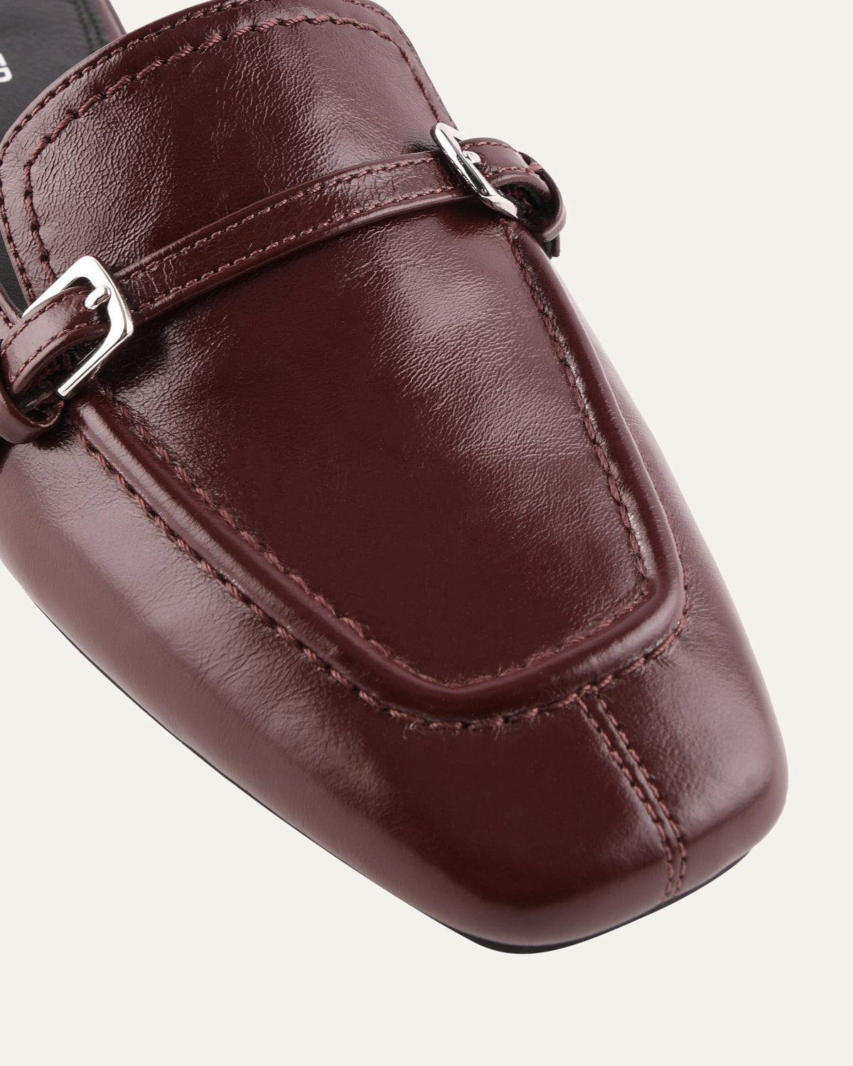 Brown leather loafer with a buckle on a white background