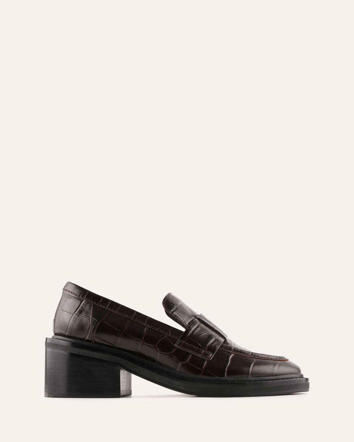 Brown loafers with a block heel on a white background