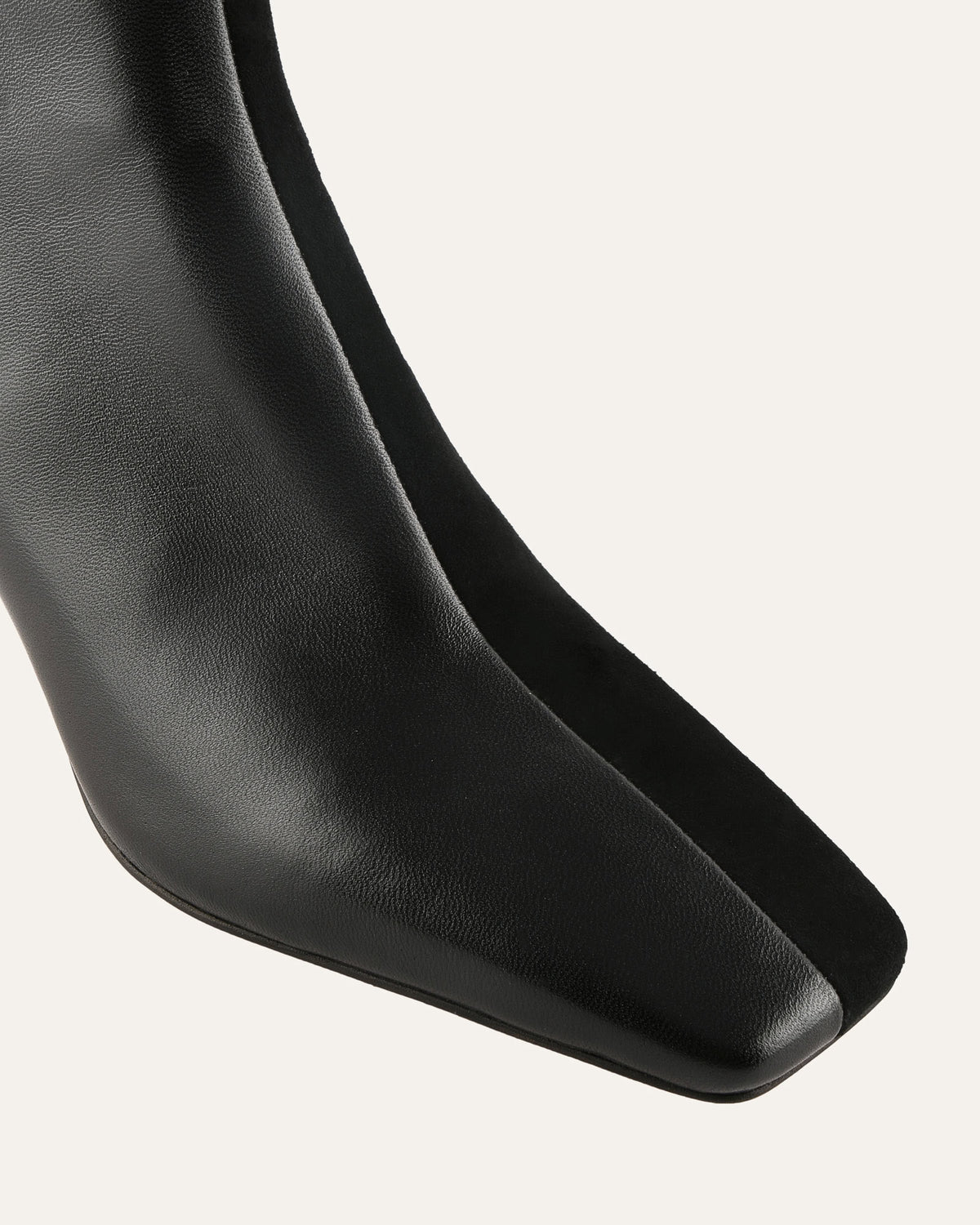 Close-up of a black leather boot sole on a light gray background
