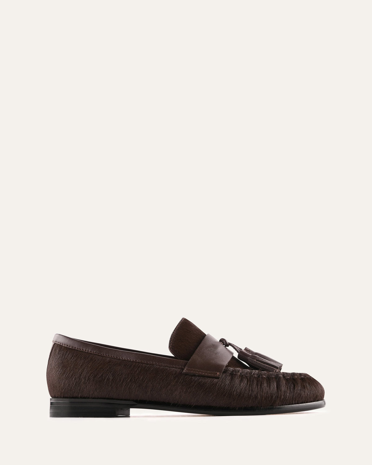 Brown loafer shoe on a light beige background