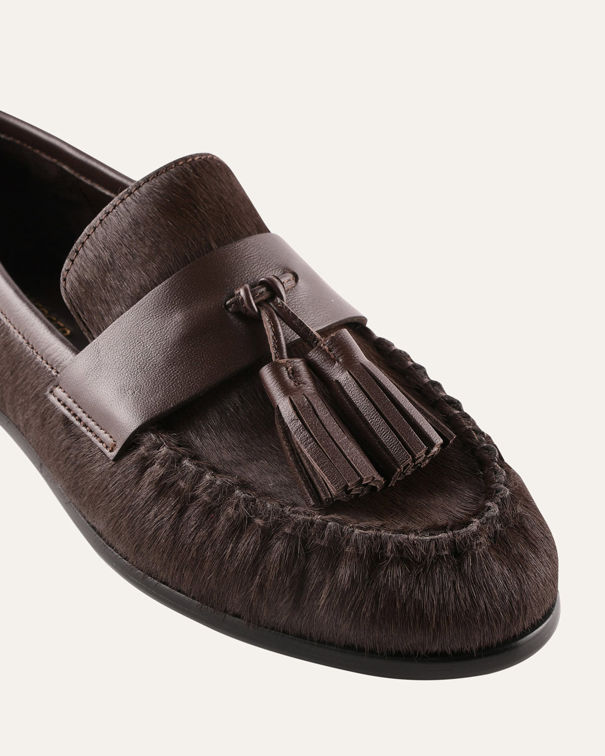 Brown loafer shoe with tassel on a white background