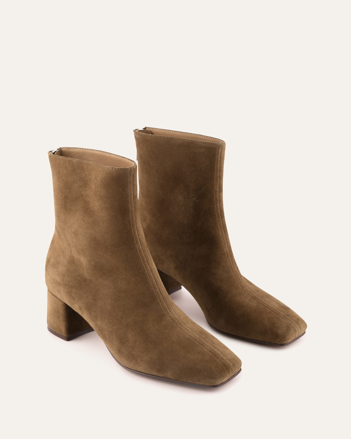 Pair of brown suede ankle boots on a white background