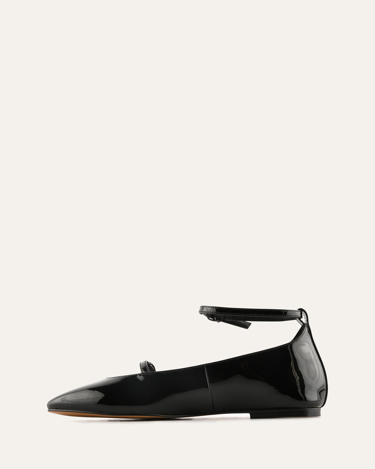 Black patent leather flat shoe on a white background
