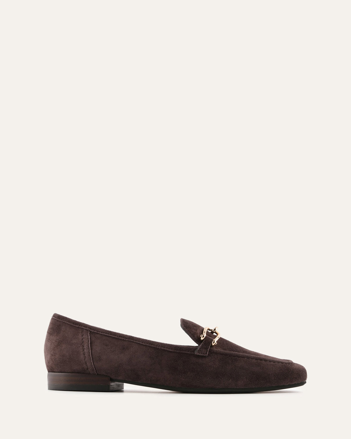 Brown suede loafer with a gold buckle on a white background