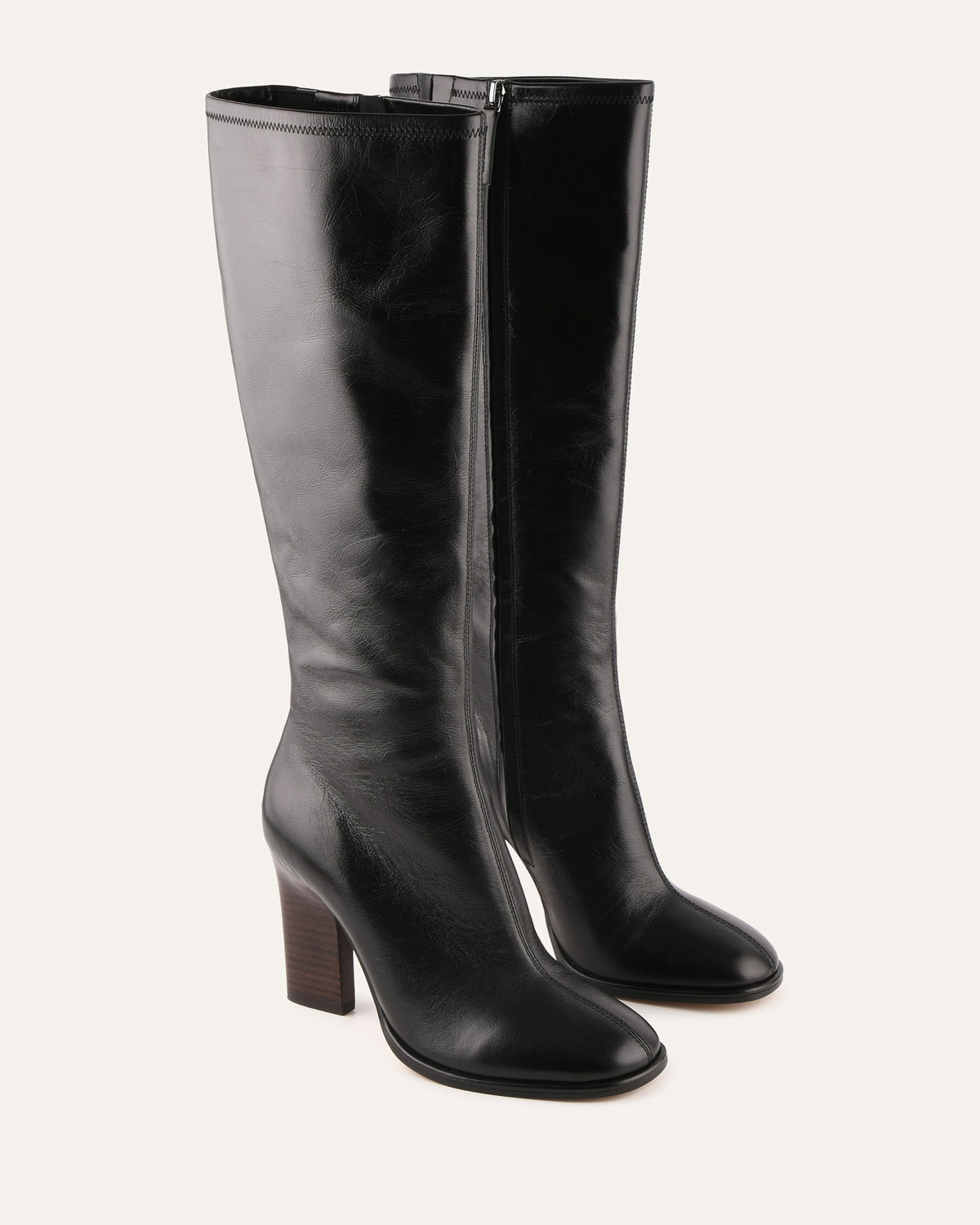 Pair of black knee-high boots on a light gray background