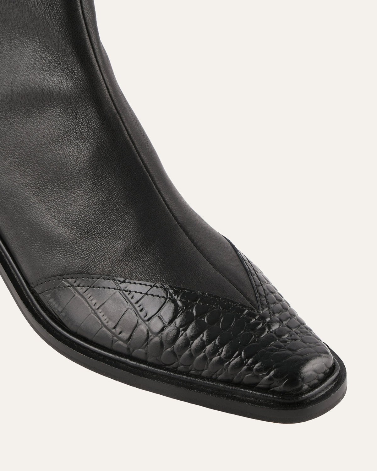 Black leather boot with a pointed toe on a white background
