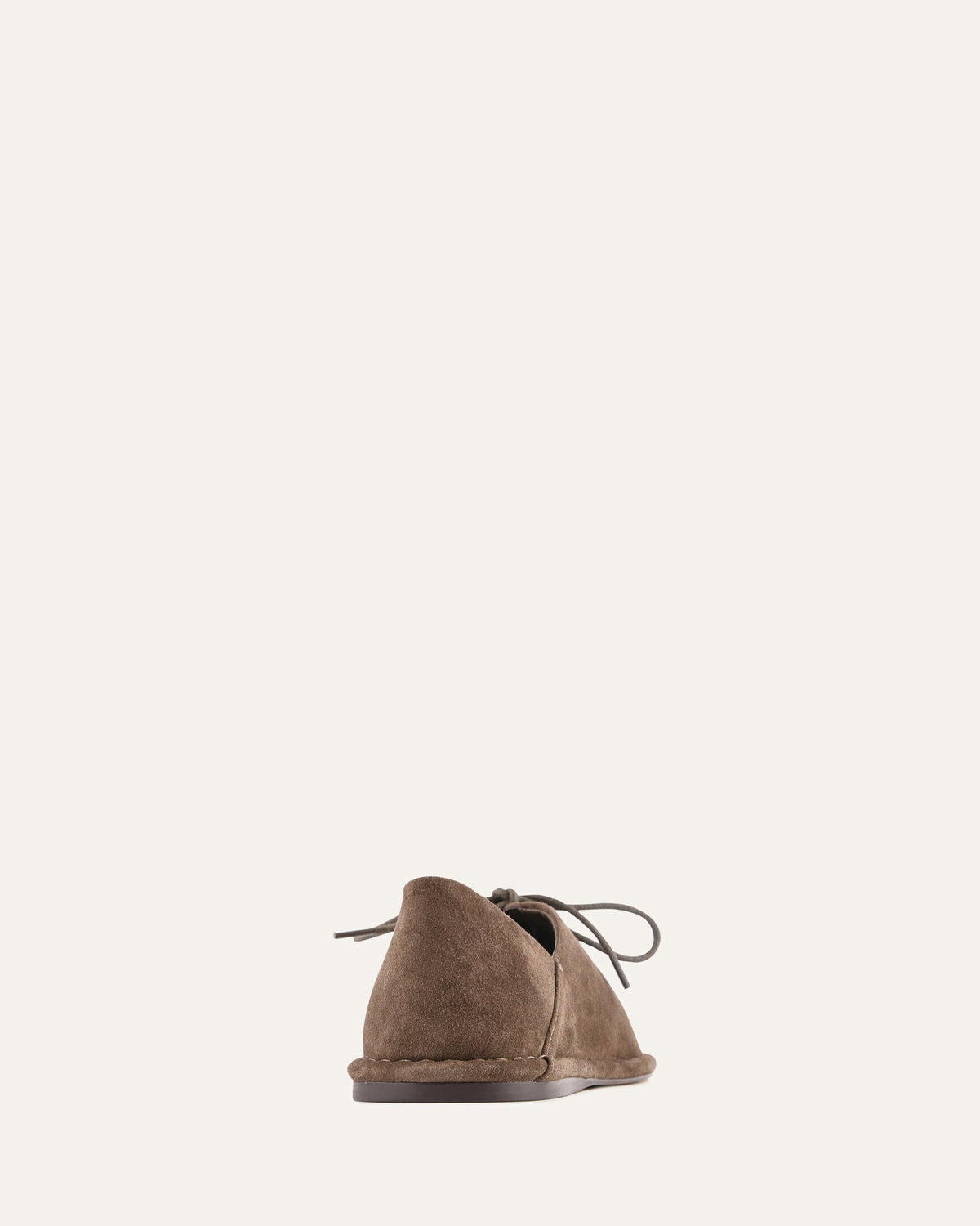 Brown suede shoe on a light beige background