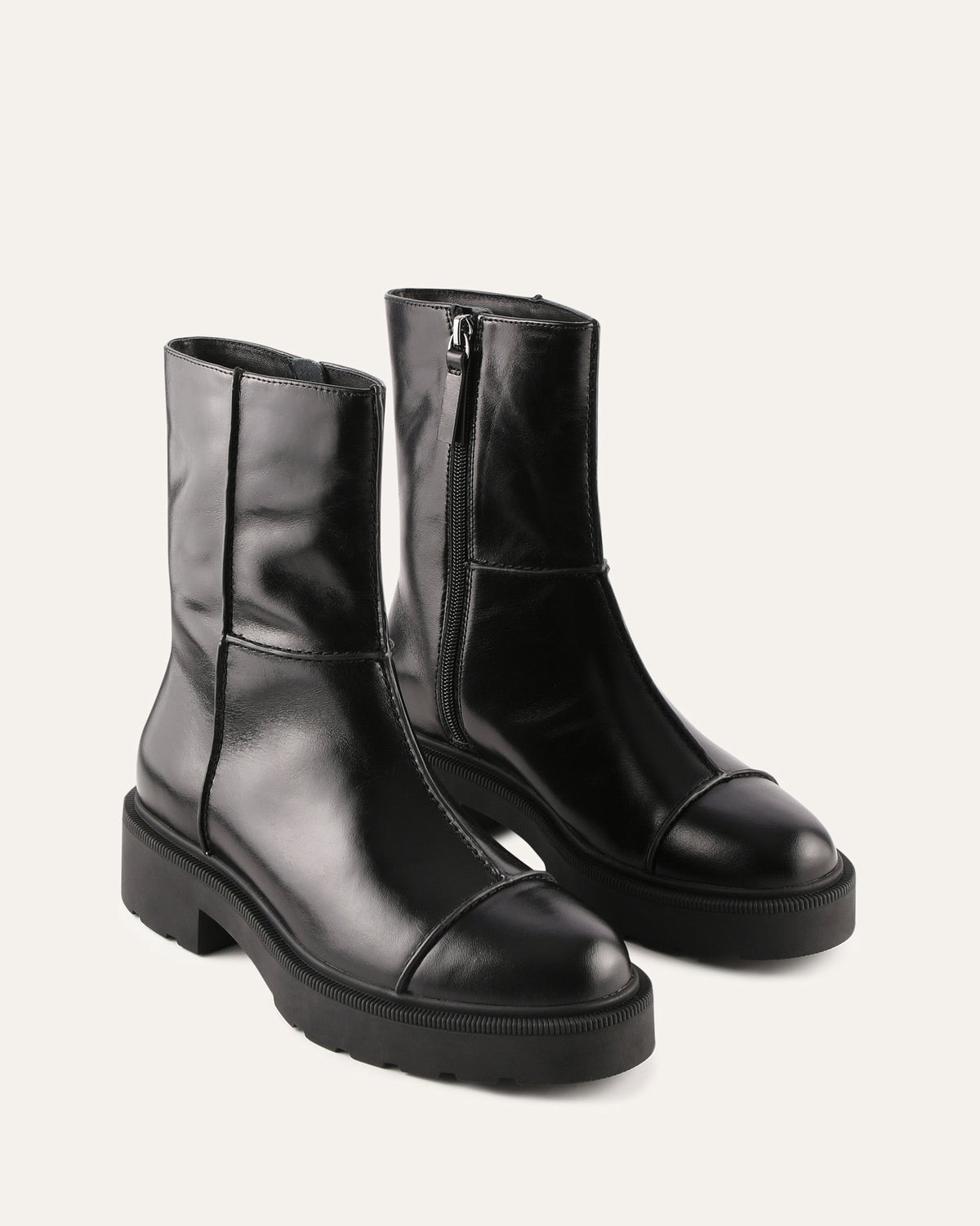 Pair of black leather boots on a light gray background