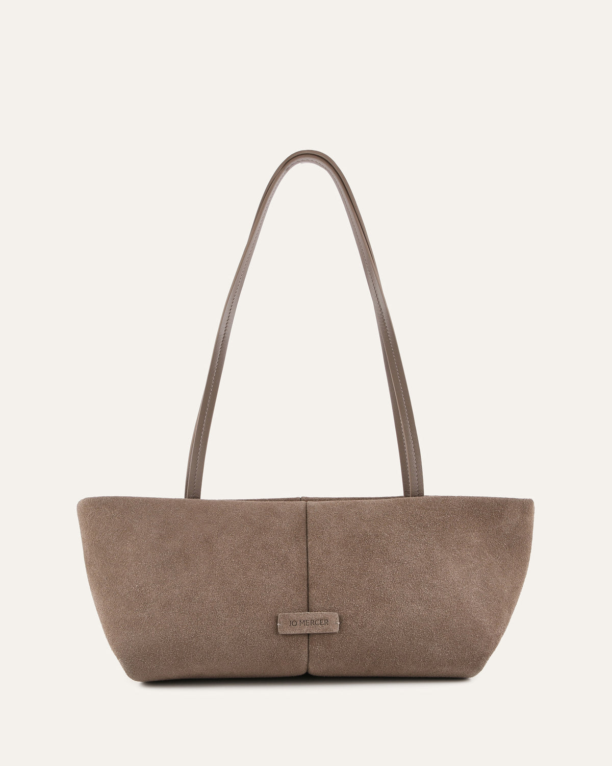 Brown handbag with a visible brand label on a light beige background