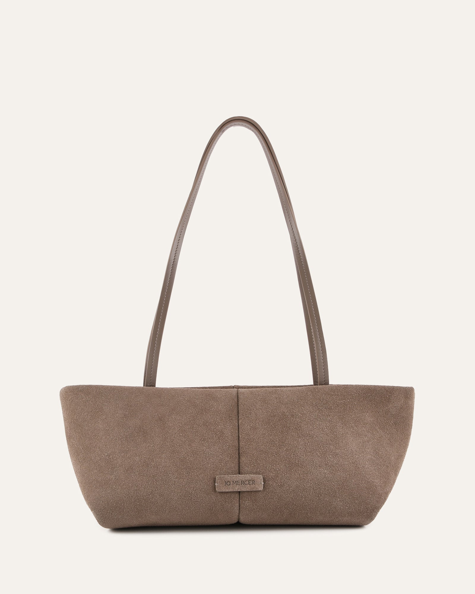 Brown handbag with a visible brand label on a light beige background