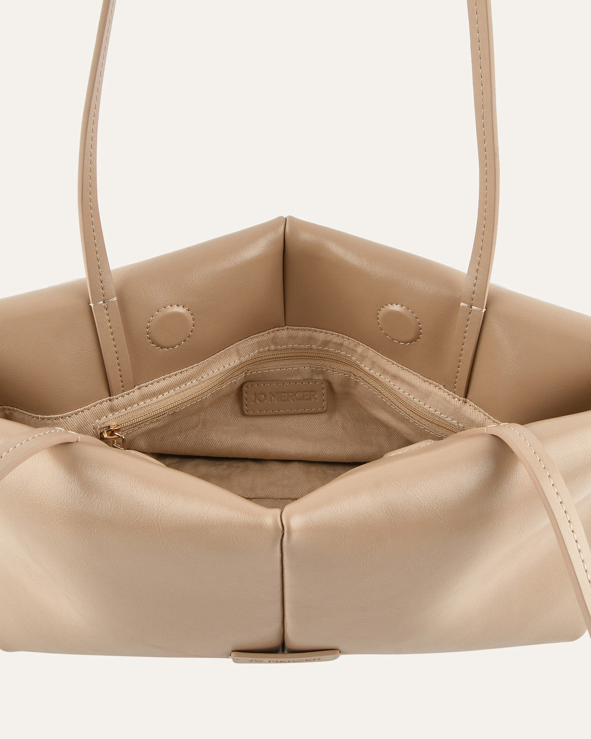 Beige handbag with visible brand logo on a light beige background