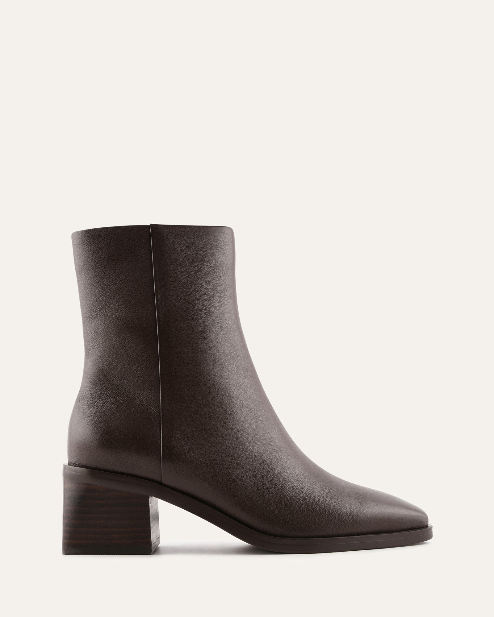 Dark brown ankle boot on a light beige background