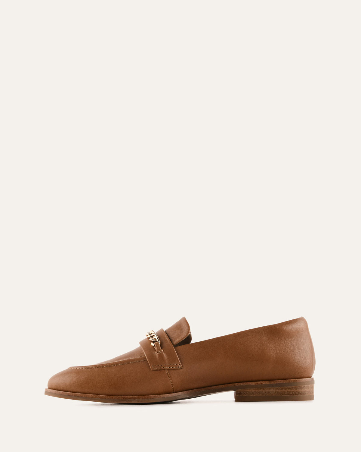 Brown loafer shoe on a light beige background