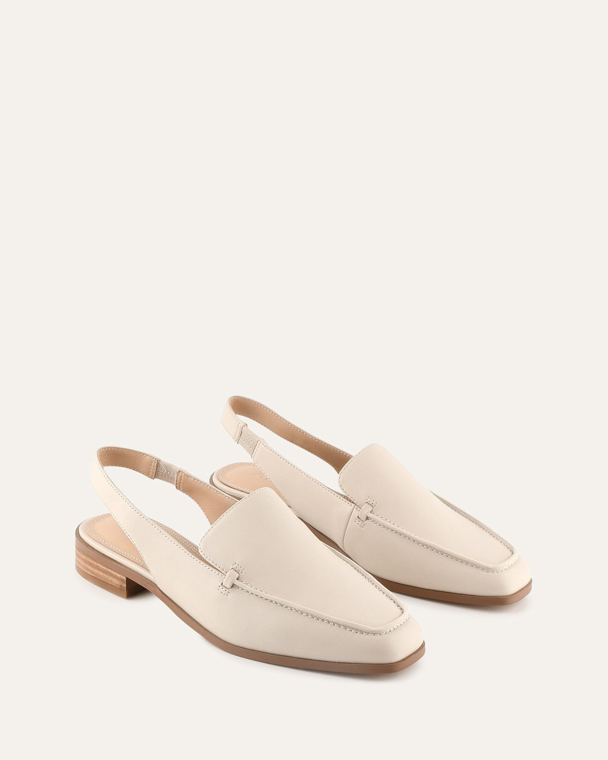 Pair of cream-colored loafers on a white background