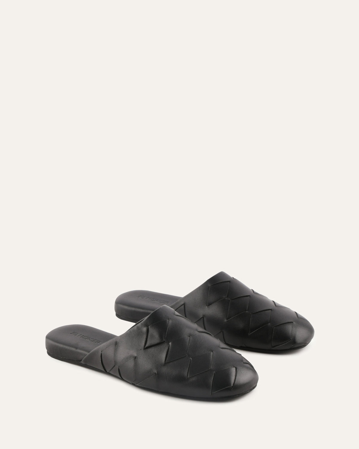 Pair of black woven slippers on a white background