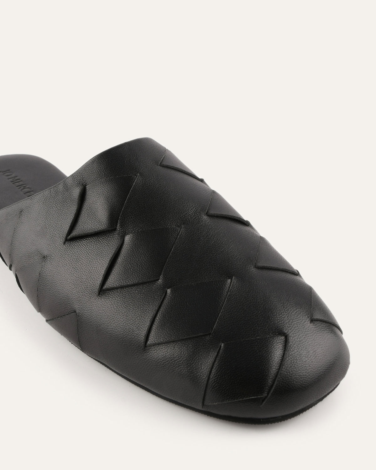 Black woven sandal on a light gray background