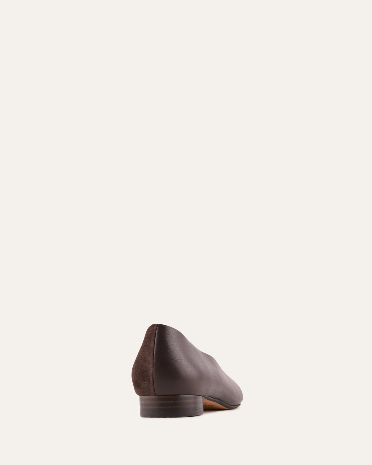 Brown leather shoe on a light beige background
