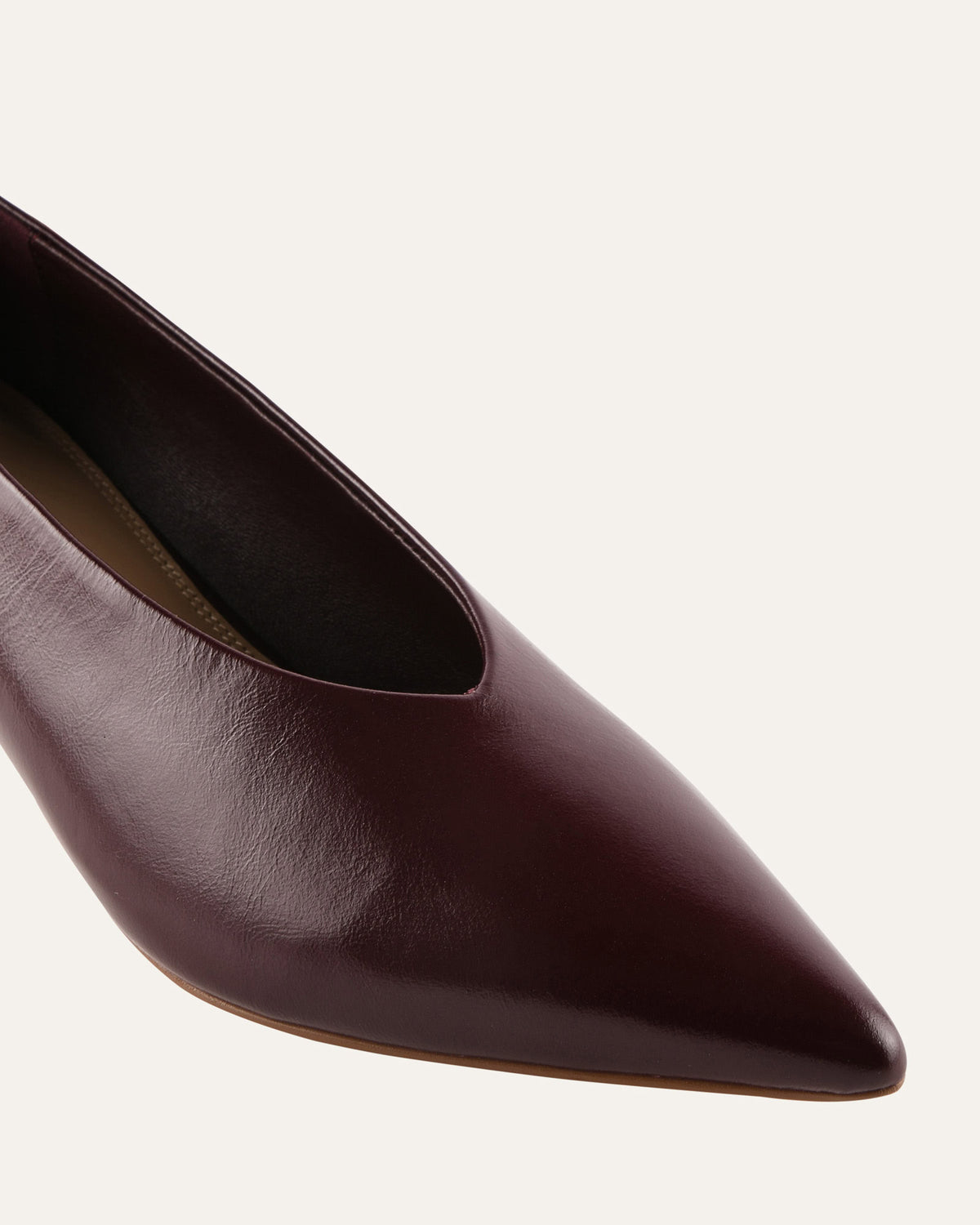 Brown leather pointed-toe shoe on a light gray background