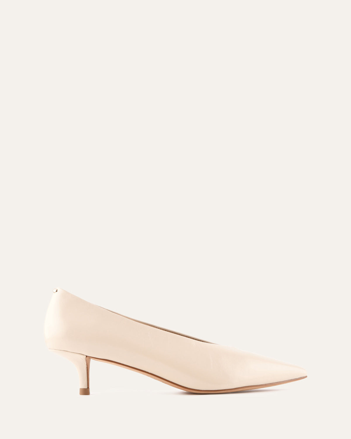 Beige high-heeled shoe on a light beige background