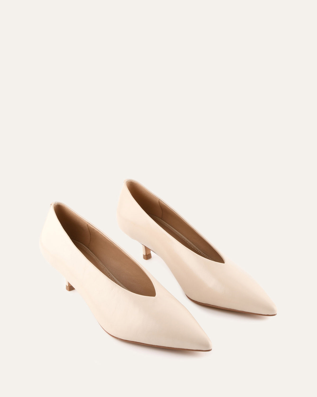 Pair of beige high-heeled shoes on a light background