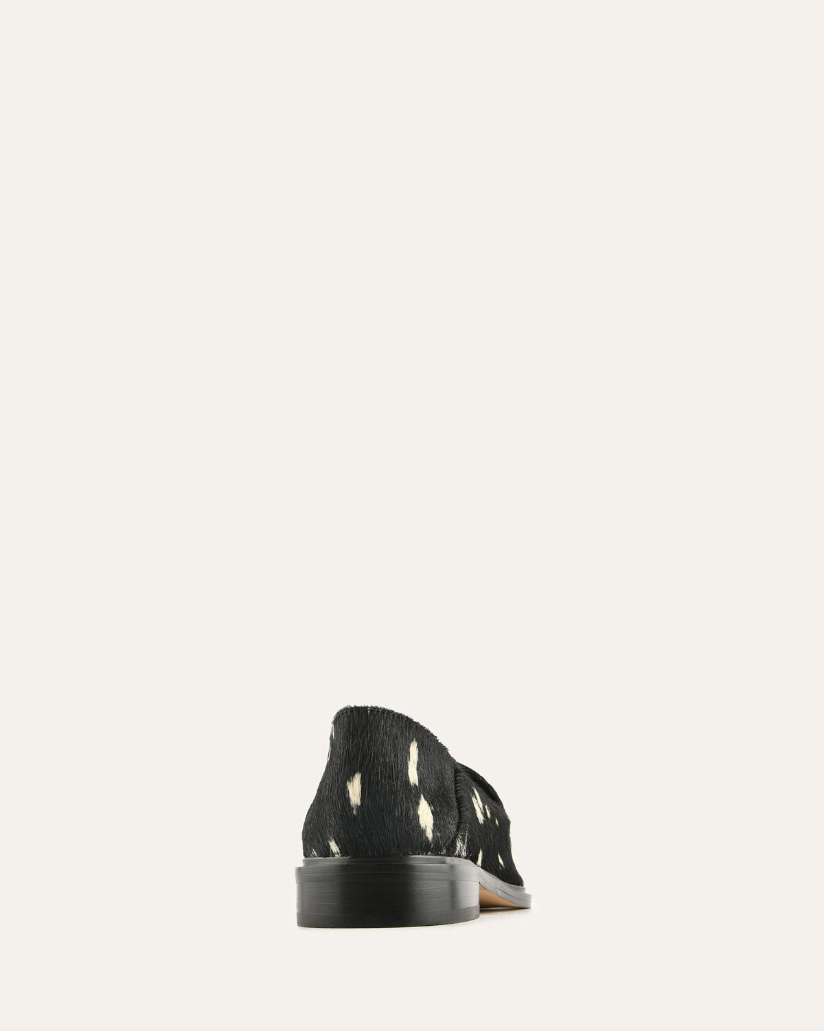 Black shoe with white patterns on a light gray background