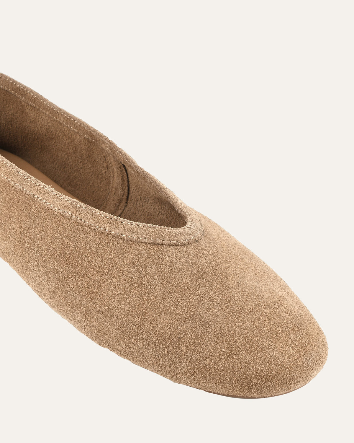 Beige ballerina shoe on a light beige background