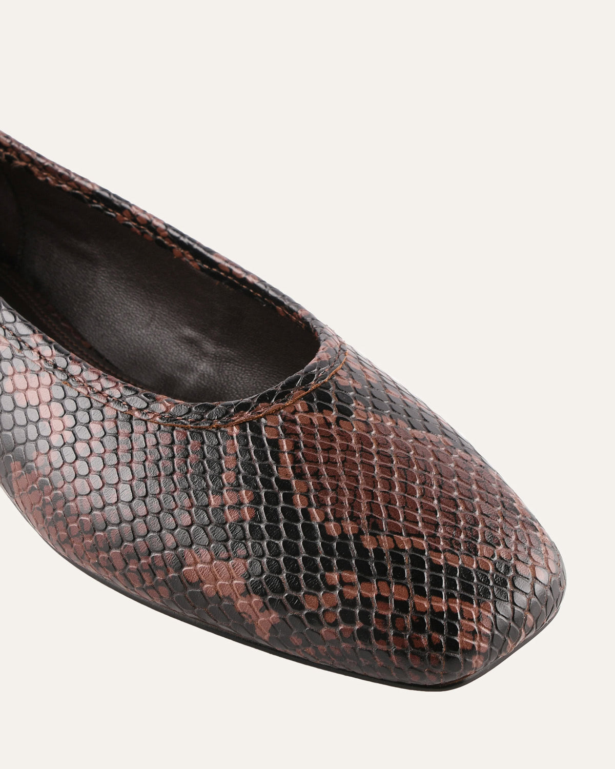 Brown and black snake print shoe on a white background