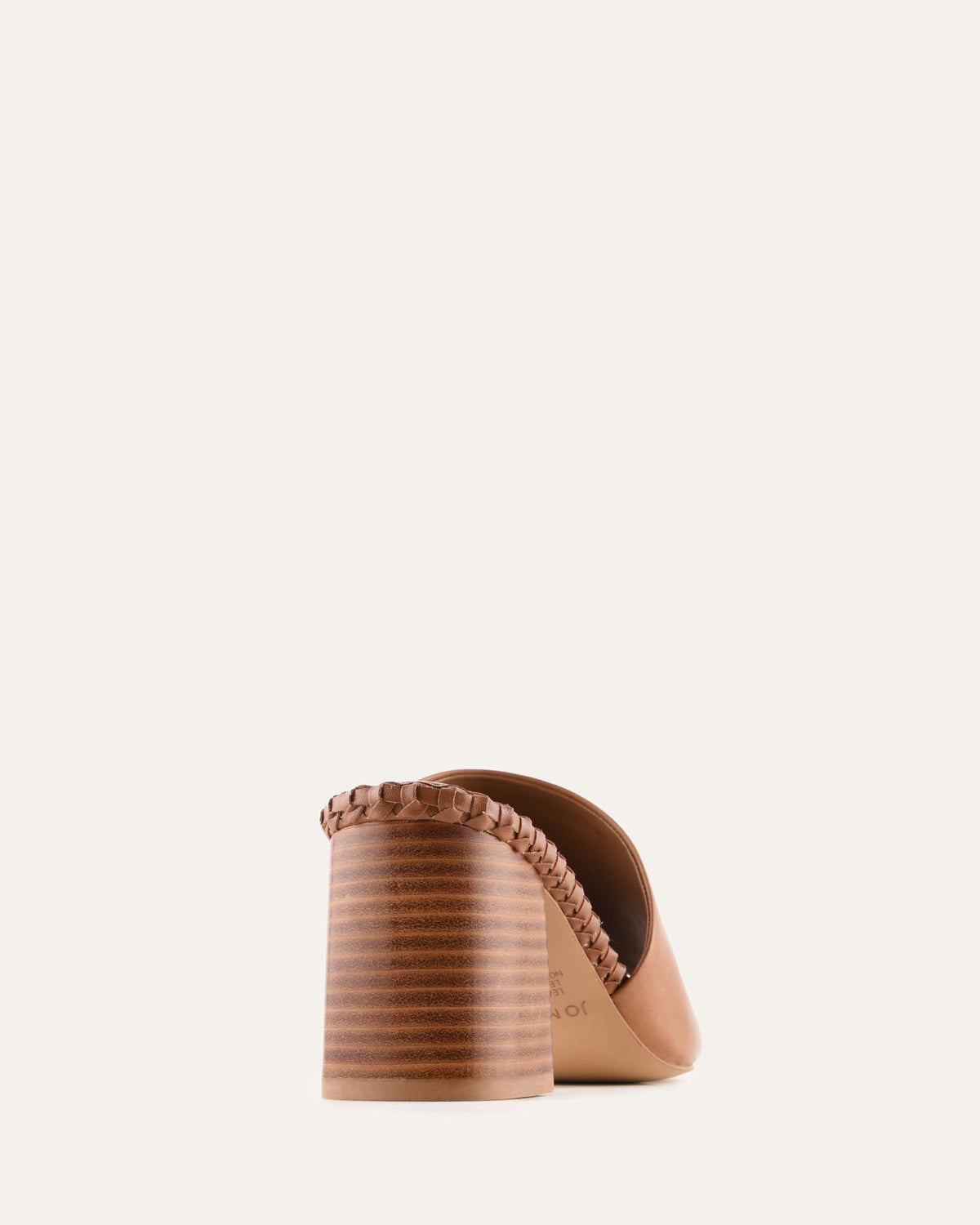 Brown sandal with a textured strap on a light beige background