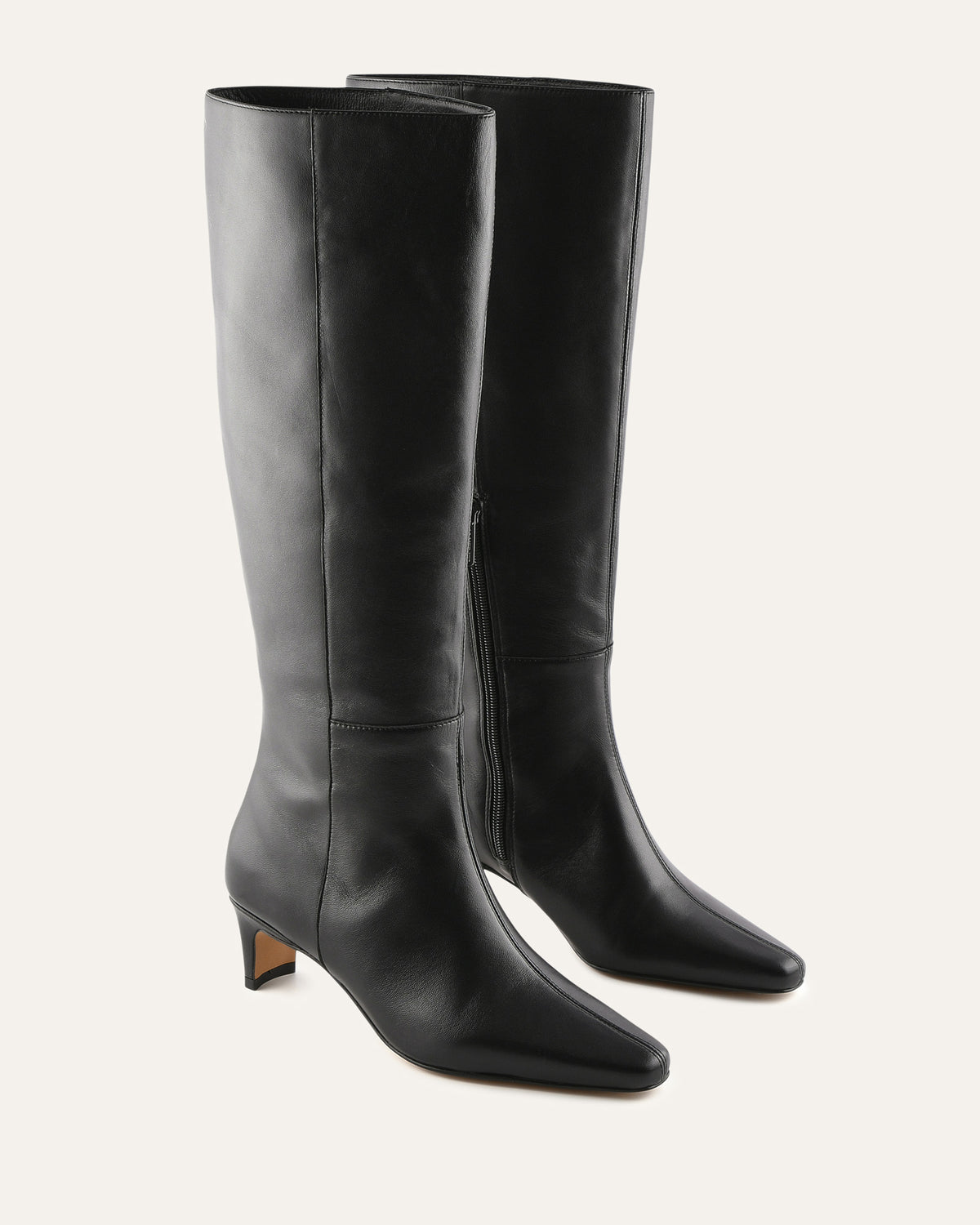 Pair of black knee-high boots on a light gray background