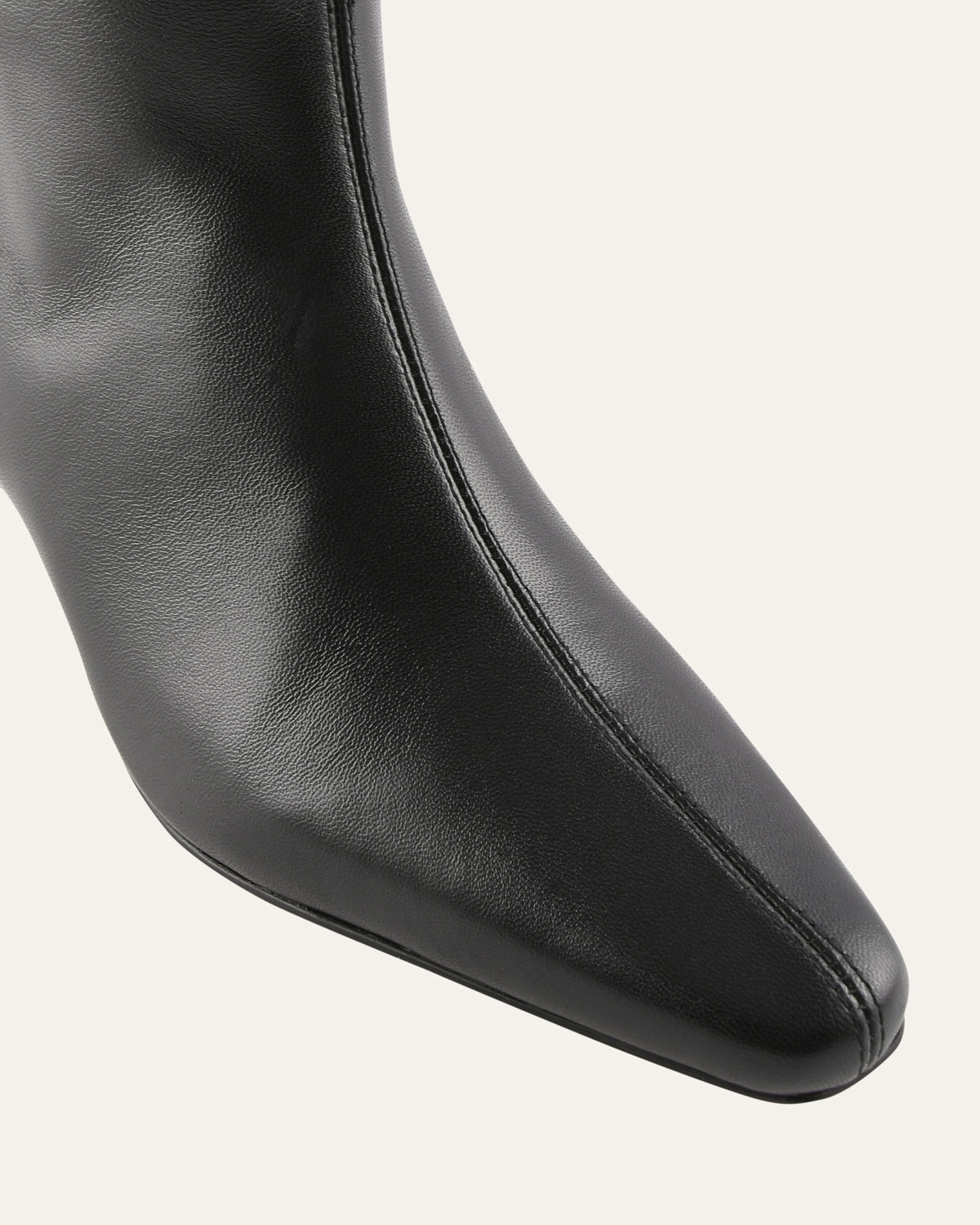 Close-up of a black leather boot on a white background