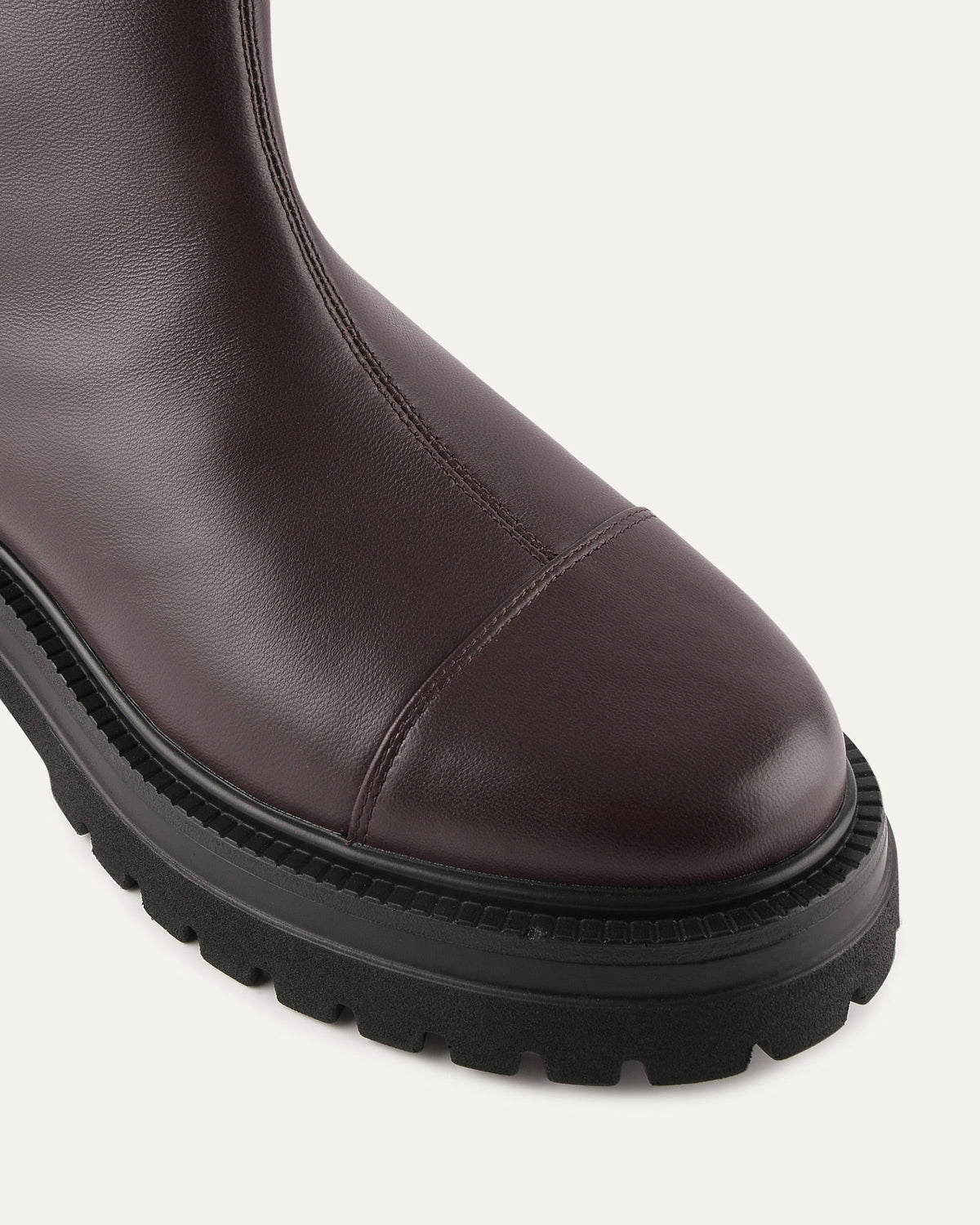 Brown leather boot with a thick black sole on a white background