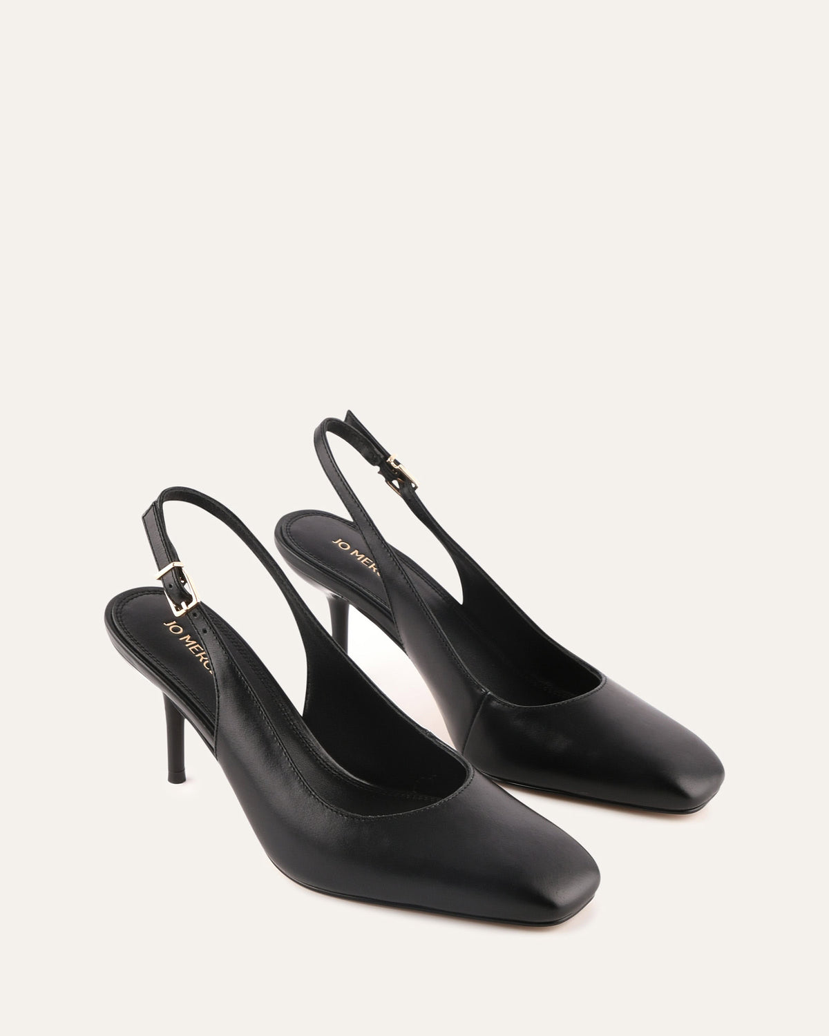 Black high-heeled slingback shoes on a white background