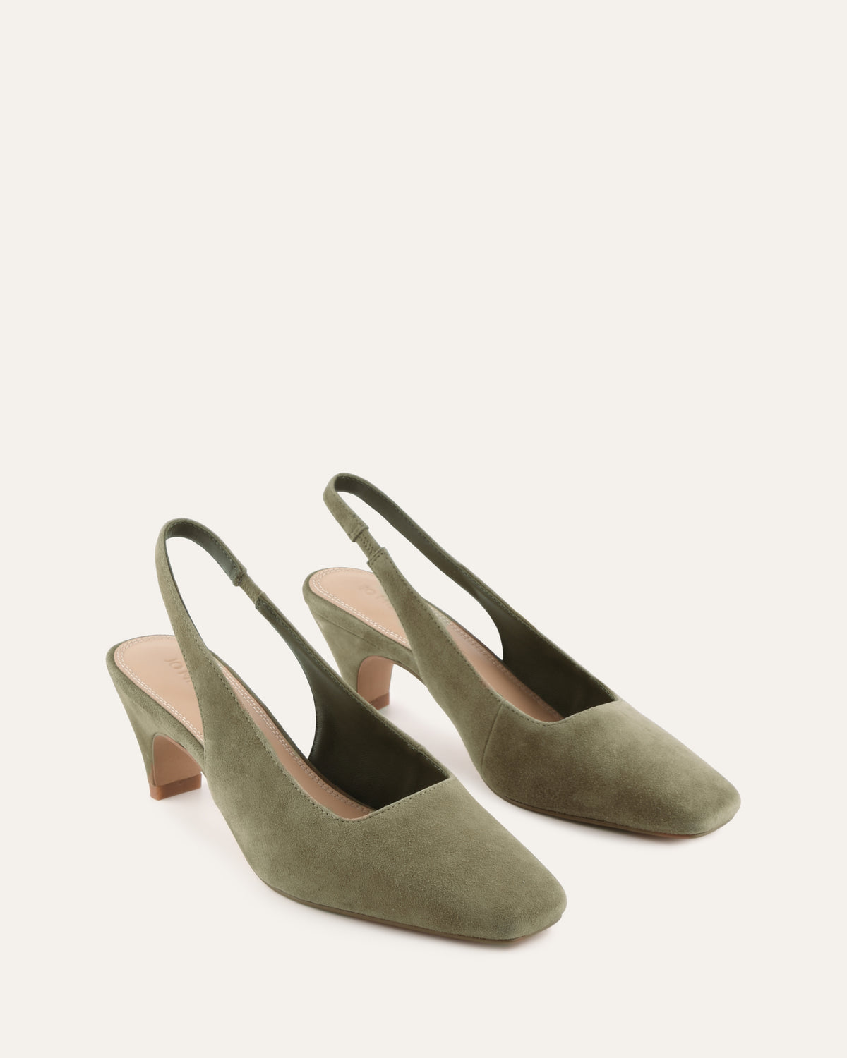 Pair of green suede slingback heels on a white background