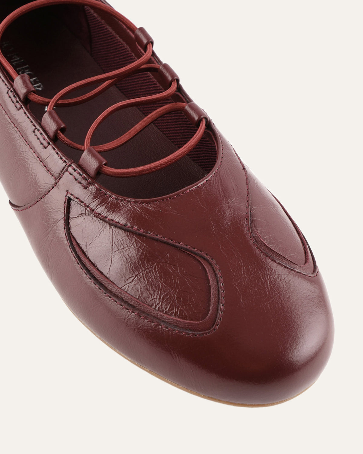 Brown leather shoe with red laces on a white background
