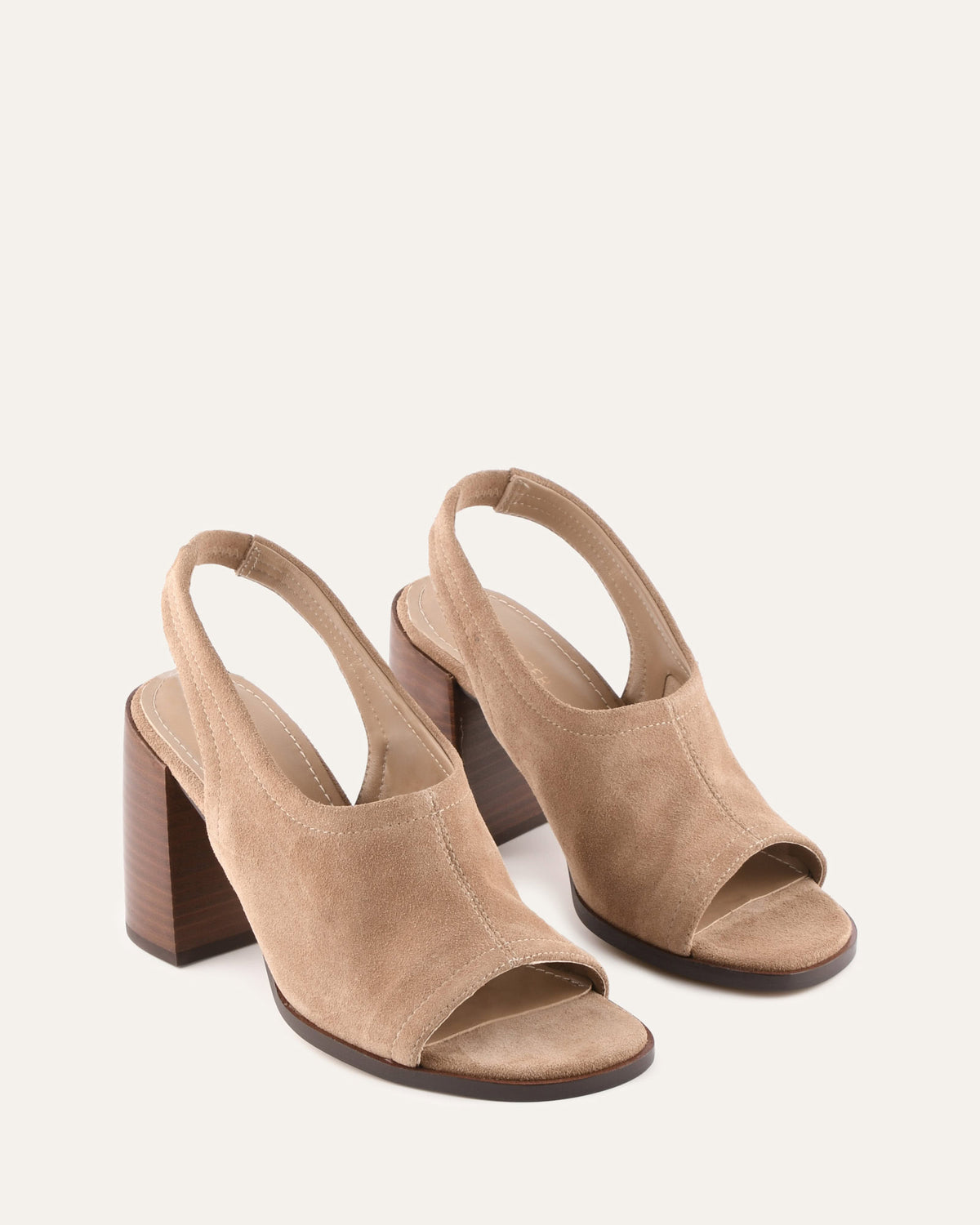 Pair of beige high-heeled sandals on a white background